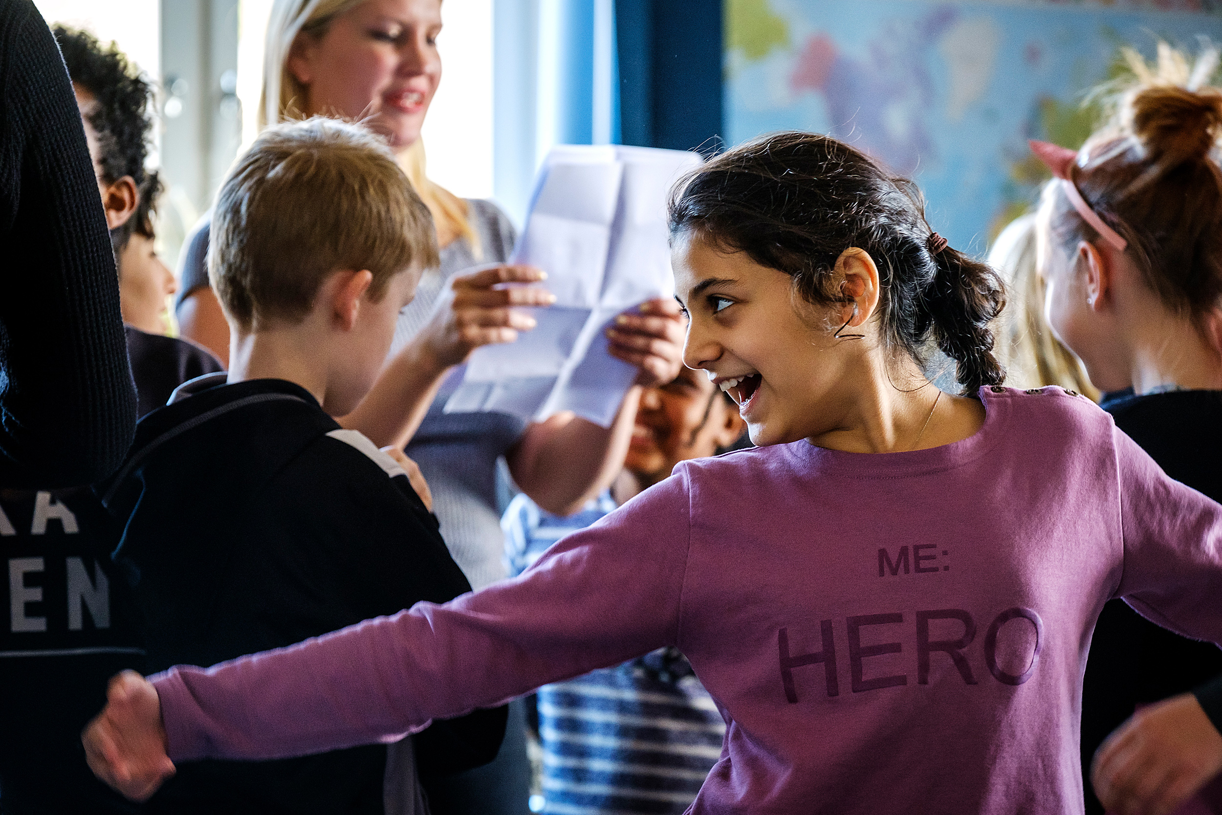 Glada barn i ett klassrum som arbetar med teater.